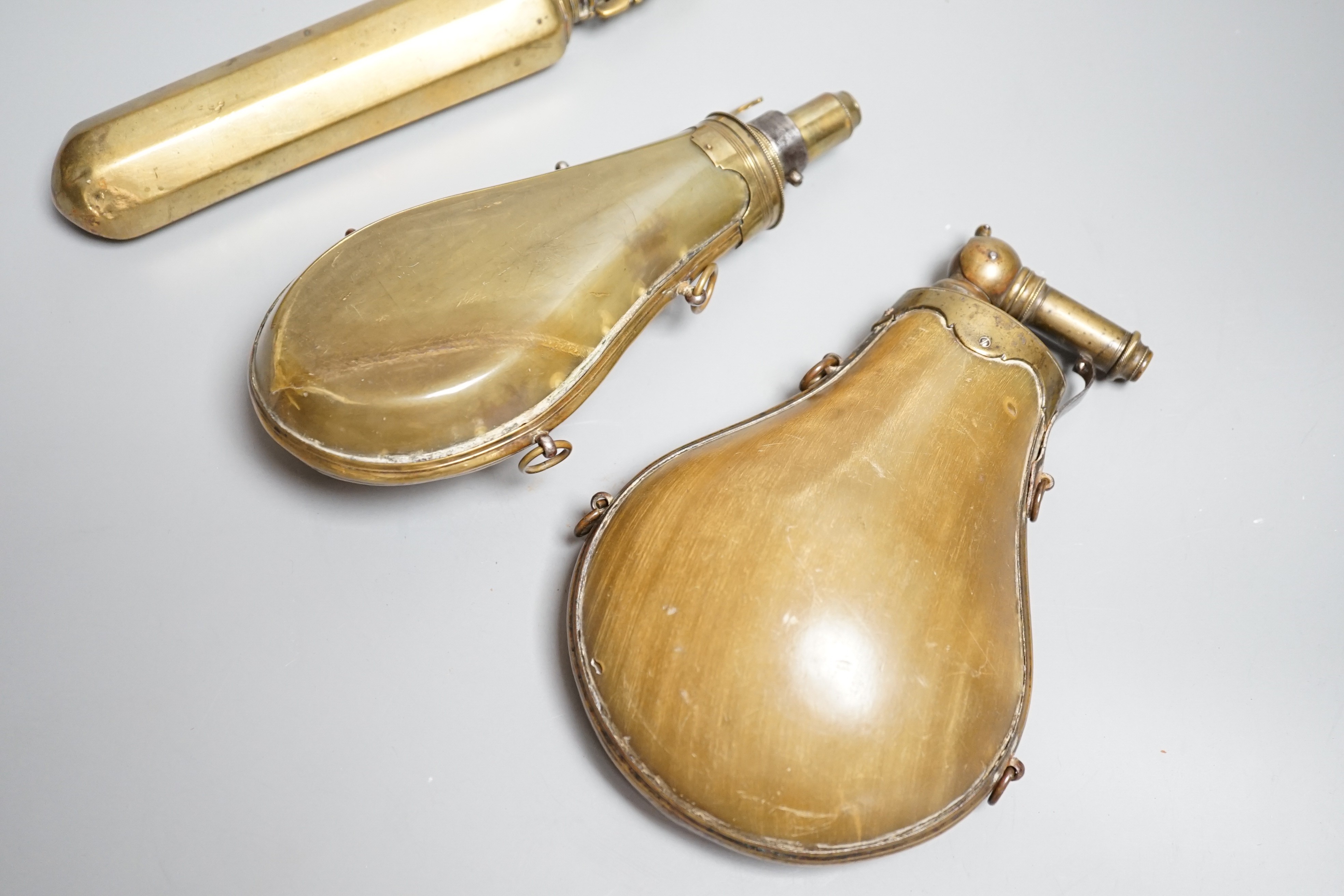 Two French lant horn powder flasks with brass mounts c.1800, one with graduated folding charger, and another unusual octagonal brass powder flask. Maximum 20cms